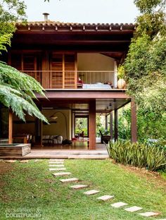 a house that is in the middle of some trees and grass with steps leading up to it