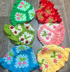 six crocheted potholders are arranged on the floor