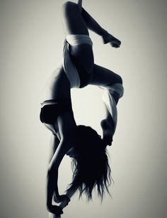 two women doing acrobatic tricks in the air on one leg and another upside down