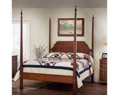 a bedroom with four poster bed, dresser and night stand in it's center