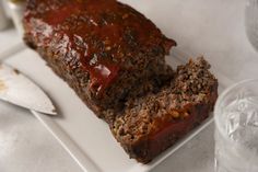 meatloaf on a white plate with knife and fork