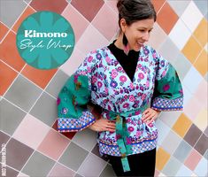 a woman standing in front of a colorful tile wall wearing a kimono style wrap