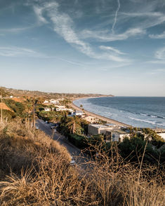 a view of the ocean and beach from a hill