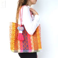 This is a colorful shopping tote handmade in Oaxaca, Mexico. Whether you're going to the beach or are just out shopping, this bag can fit all your needs! The embellished heart is detachable and handmade as well.  This bag is made out of recycled plastic, it is waterproof and can be hand washed. Please note all bags are handmade and might have some slight imperfections! Tote measures approx. 14-inch x 13-inch x 5-inch. The handles are long and extend 10 inches from the bag of the body. Plastic Shop, Wedding Bags, Going To The Beach, Accessories Bags Purses, Wedding Bag, Shopping Tote Bag, Shopping Tote, Bags Purses, Medium Bags