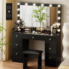 a vanity with lights on it and a stool in front of the mirror that is lit up