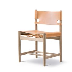 a wooden chair with a leather seat and back rest on an isolated white background,