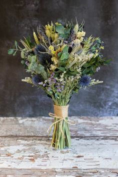 a bouquet of wildflowers tied up in a vase