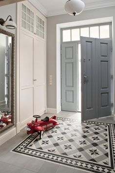 a toy airplane sitting on the floor in front of a mirror