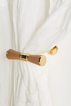 a pair of gold and brown handles on a white shirt