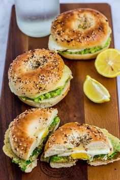 the sandwich is cut in half and ready to be eaten on the cutting board with lemon wedges next to it