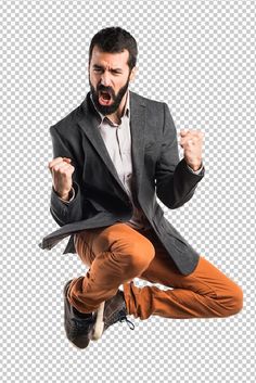 a man jumping in the air with his arms wide open, wearing an orange pants and jacket