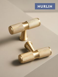 two gold - plated metal handles are shown on a white surface with the words nurlin above them