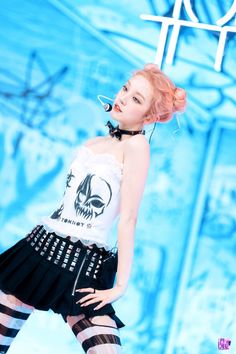 a woman with pink hair wearing black and white clothing, tights and stockings is standing in front of a blue background