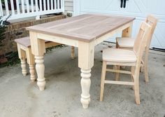 a wooden table and two chairs sitting in front of a garage door