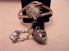 "Vintage silver tone signed ECJ jewelry was made in the 1990's. This adjustable cuff bracelet features an American eagle head with attached chain and matching ring. The bracelet measures 5\" inside and can be adjusted. The eagle head measures 1\" tall x 1\" wide on the bracelet and .75\" wide x .75\" tall on the ring. The chain between the bracelet and ring is 4.5\" long. In very good condition. Available in US ring size 10, size 7, and size 5.5." Vintage Metal Jewelry For Collectors, Adjustable Antique Silver 925 Jewelry, Nickel-free Antique Silver Bracelet, Antique Adjustable Nickel-free Jewelry, Stamped Metal Bracelet Jewelry, Adjustable Stamped Jewelry For Collectors, Collectible Hallmarked Metal Jewelry, Vintage Adjustable Silver Jewelry, Adjustable Vintage Silver Jewelry