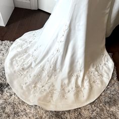 the back of a wedding dress on display in front of a white door and rug