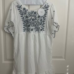 White Beach Dress Flowy Midi Dress For Spring Beach Cover-up, Casual Flowy Midi Dress For Beach Cover-up, Flowy Casual Midi Dress For Beach Cover-up, Breezy White V-neck Mini Dress, Beach Floral Embroidered Maxi Sundress, Floral Embroidered Sundress Maxi Dress For Vacation, Beach Sundress With Floral Embroidery, Floral Embroidery Sundress Maxi For Summer, Floral Embroidery Sundress For Summer