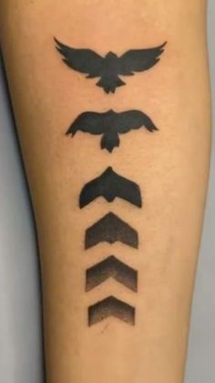 a tattoo on the leg of a person with an eagle and arrows in different directions