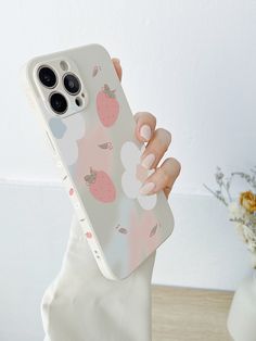 a woman holding up her phone case with an apple print on the front and back