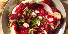 a white plate topped with cranberry sauce and almonds next to crackers