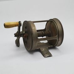 an old metal spinning machine with a wooden handle