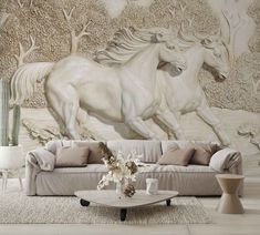 a living room with a couch, coffee table and wall mural