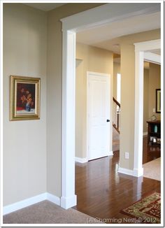 an empty living room with hardwood floors and white trim on the walls is seen in this image