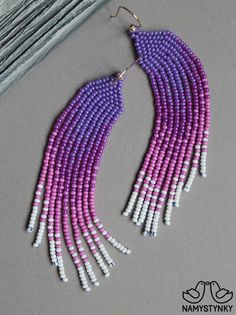 purple and white beaded earrings with long fringes on the end of each ear