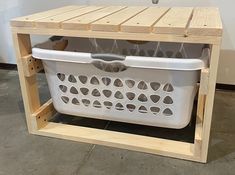 a white laundry basket sitting on top of a wooden shelf