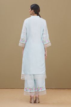 Blue straight kurta with stitching details, delicate floral embroidery at the sleeves and hem. Comes with palazzo and yellow dupatta.
Component: 3
Embroidered
Neckline: V-Neck
Sleeve Length: Full
Fabric: Kurta and Palazzo: Chanderi; Dupatta: Chiffon
Color: Blue
Straight kurta
Front button placket
Embroidered buttons
Tassels at the hem of dupatta - Aza Fashions Light Blue Straight Kurta Salwar Kameez, Designer Blue Palazzo Set With Embroidered Border, Blue Embroidered Palazzo Set For Designer Outfits, Blue Cotton Silk Kurta With Embroidered Border, Blue Palazzo Set With Floral Embroidery And Straight Kurta, Light Blue Straight Kurta With Resham Embroidery, Yellow Dupatta, Chiffon Embroidery, Embroidered Buttons