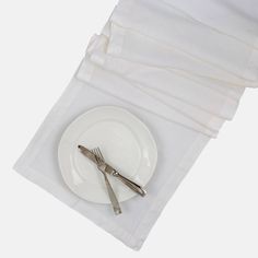 a white plate with silverware on it next to some napkins and utensils