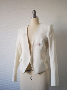 Ivory jacket, princess cut, 2 embroideries on the front handmade. Material: Ext: 65% polyster, 33% viscose, 2% elastane Int: 100% polyester Size S (curved) Fitted Floral Embroidered Outerwear For Wedding, Fitted Wedding Outerwear With Floral Embroidery, Formal Fitted Blazer With Floral Embroidery, Elegant Blazer With Floral Embroidery For Wedding, Elegant Floral Embroidered Blazer For Wedding, Spring Tailored Blazer With Embroidery, Spring Embroidered Tailored Blazer, Fitted Embroidered Blazer For Tailoring, Spring Tailored Embroidered Blazer