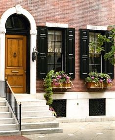 an advertisement for a wood door with flowers in the window boxes and on the steps