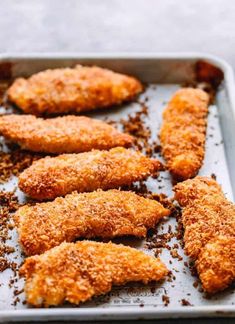 chicken tenders on a baking sheet covered in seasoning sprinkled with brown sugar