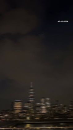 the city skyline is lit up at night, and it appears to be very dark