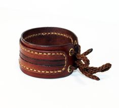 Hand-tooled Leather Cuff Bracelet, Handmade Leather Wristband For Festival, Adjustable Hand Tooled Leather Bracelet, Rustic Leather Cuff Bracelet, Adjustable Leather Wristlet With Wrist Strap, Brown Hand-stitched Leather Bracelet, Hand Tooled Leather Cuff Bracelet, Handmade Leather Cuff Wristband, Adjustable Leather Cuff Bracelet Hand-stitched