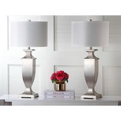 two lamps sitting on top of a table next to a vase with flowers in it