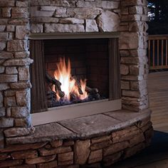 a stone fireplace with fire burning in it