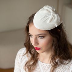 Bridal pillbox hat draped with ivory silk velvet having just a decent shine, adorned with a bow.  This millinery hat is complete handmade - hand blocked, shaped, covered with silk velvet fabric, lined on the inside and trimmed. The edge of hat is wired for long lasting durability and hand finished with a petersham ribbon and lining.  The hat is carefully designed to offer both style and comfort on your special day. The pillbox attaches to hair with hat elastics. It rests securely on your head, a Hair With Hat, Hat With Bow, Bow Wedding, Silk Velvet Fabric, Velvet Hat, Millinery Hats, Pillbox Hat, Wedding Bows, Ivory Silk