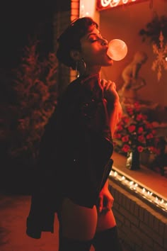 a woman standing in front of a building blowing bubbles into the air with her mouth