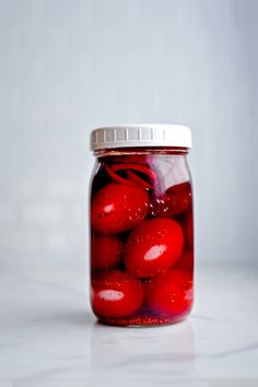 a glass jar filled with red jelly beans