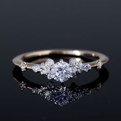 a three stone diamond ring on a black surface