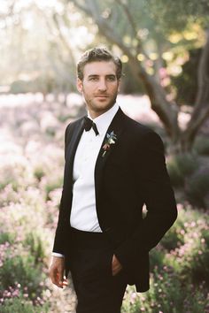 a man in a tuxedo poses for a photo