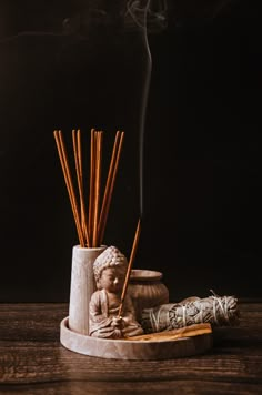 incense sticks and an angel statue on a wooden table