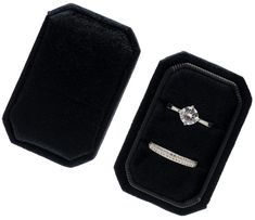 a black velvet case with a diamond ring in the middle and a white gold band around it