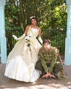 two people dressed as princesses posing for a photo in front of a gazebo