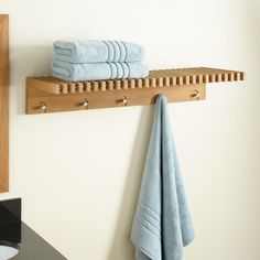 towels are hanging on a wooden shelf in the bathroom