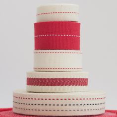 three red and white ribbons stacked on top of each other