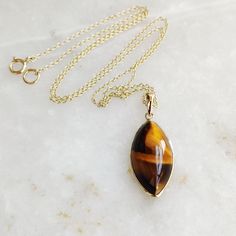 "You can choose your own gem in my store. Let me know if you would like to see options Gemstone: Brown YellowTiger Eye Gold Purity : Guaranteed 14kt pure GOLD Gem weight 9.60 carats Gem shape: Marquis Cabachon shape Gold weight: 0.56 grame Total weight: 2.48 grame The Gemstone in this pendant is ethically sourced and is exploitation free. Brown Yellow Tiger Eye is a beautiful Gemstone of patterns like no other Gemstone. Please note that the pendant is made with absolutely pure 14kt Gold. Pendant 14k Gold Gemstones With Bezel Setting For Gift, 14k Yellow Gold Gemstones For Gift, Yellow Gold Cabochon Teardrop Pendant Necklace, Fine Jewelry Cabochon Necklaces For Anniversary, 14k Gold Cabochon Necklace Fine Jewelry, Teardrop Bezel Set Necklace Gift, Gold Hallmarked Marquise Jewelry, Yellow Gold Cabochon Necklace For Anniversary, Anniversary Fine Jewelry Necklace With Cabochon