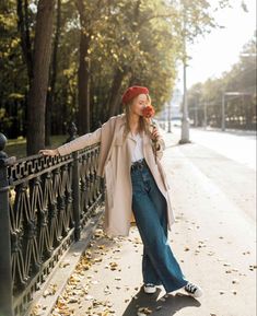 a woman leaning on a fence with her arms outstretched